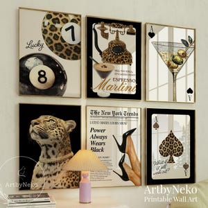 May include: A collection of framed wall art featuring a leopard print theme. The art includes a pool ball, a martini glass, a leopard, a telephone, a playing card, and a fashion-themed poster. The frames are gold.