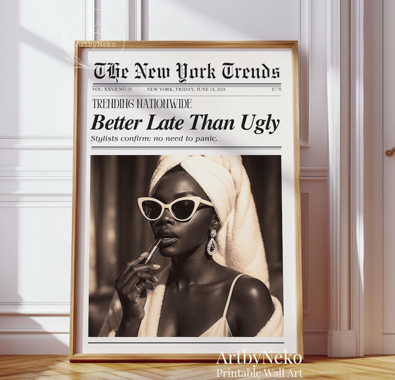 May include: A framed sepia-toned print featuring a woman applying lipstick, wearing sunglasses and a towel. The print is designed to look like a newspaper, with the headline "Better Late Than Ugly."