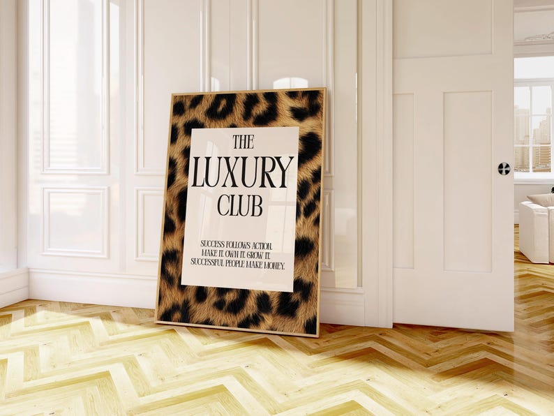May include: A framed print with a leopard print border and the words "THE LUXURY CLUB" in bold black letters. The print also includes the text "SUCCESS FOLLOWS ACTION MAKE IT OWN IT GROW IT SUCCESSFUL PEOPLE MAKE MONEY."