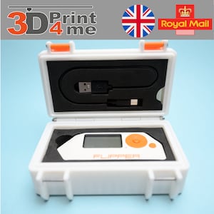 May include: A white hard case with orange accents, containing a small white device with a black screen and orange button. The device is labelled "FLUPPER".