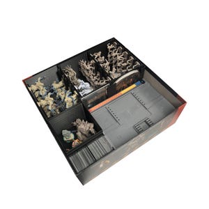 Peut inclure: Un organisateur de jeu de société noir avec plusieurs compartiments remplis de pièces de jeu, de cartes et de figurines. L'organisateur est conçu pour contenir divers composants, y compris des figurines et des cartes de jeu.