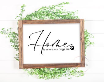 May include: A wooden framed sign with the text "Home is where my dogs are" in black script font with a paw print icon.