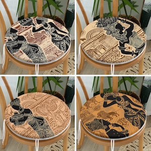 May include: Four round chair cushions featuring black silhouettes of figures and animals against tan and brown backgrounds with intricate geometric patterns, tribal motifs, and wildlife illustrations including zebras, lions, and elephants.