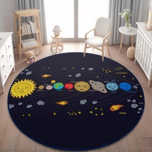 May include: A round, navy blue rug featuring a colorful illustration of the solar system. The design includes a smiling sun, planets with faces, comets, and constellations. The rug is a decorative item for a child's room.