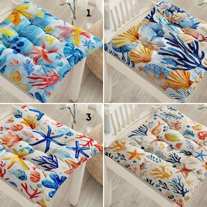 Peut inclure: Quatre coussins de chaise différents avec des motifs nautiques variés. Les coussins sont tous carrés et ont un design matelassé. Les motifs comprennent des étoiles de mer, des coquillages, des coraux et des algues.