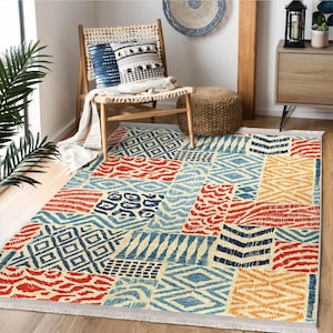 Peut inclure: Un tapis rectangulaire avec un motif patchwork. Le tapis présente divers motifs géométriques et abstraits dans des tons de rouge, de bleu et de jaune sur un fond crème. Le tapis a une bordure à franges et est posé sur un sol en bois.