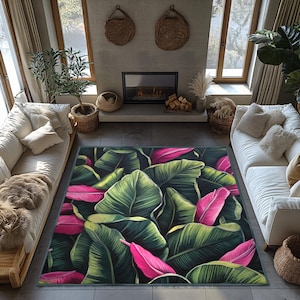May include: A tropical-themed rug with large green leaves and pink flowers. The rug is laid out on a hardwood floor in a living room setting.