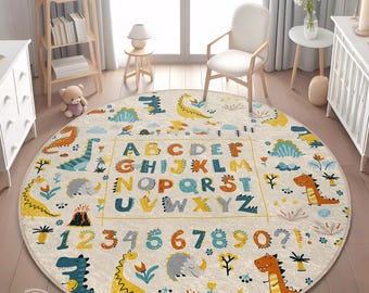 May include: A round, cream-colored play rug with a colorful alphabet, numbers, and dinosaurs. The rug features a yellow, orange, blue, and green color scheme.