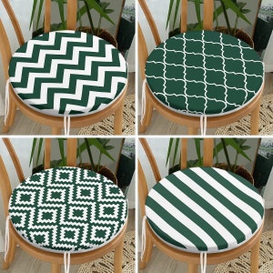 May include: Four different chair cushions with green and white patterns. The cushions are round and have a variety of geometric designs, including zigzags, squares, and stripes.