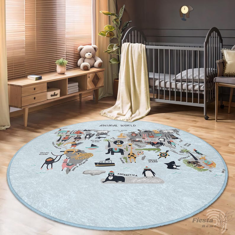 May include: A round, light blue rug with a world map design featuring animal illustrations. The rug has a light blue border and the words "ANIMAL WORLD" are printed at the top. The rug is placed on a wooden floor.