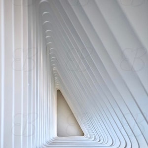 Puede incluir: Una estructura blanca geométrica con una serie de líneas curvas y superpuestas que crean una forma triangular. Las líneas crean un efecto de túnel, que conduce a un espacio blanco brillante al final.