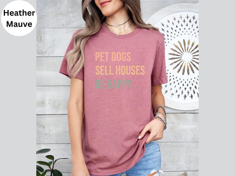 a woman wearing a realtor t - shirt that says pet dogs sell houses be happy