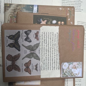 May include: A stack of brown paper packages with colorful butterfly stickers and text that reads "I'll be honest. Had to pluck up all me courage to type a proper message to Shell. She was out a my league then and I'm just as tongue-tied now. Turns out I needn't have worried. Soon as I mention meeting up she replies with YEAH, drop in when- ever you're passing, have a catch-up, be good to see you. So I type back GREAT, see you in an hour (...) She takes a while to reply then. Probably busy putting the Hoover™ round and baby"