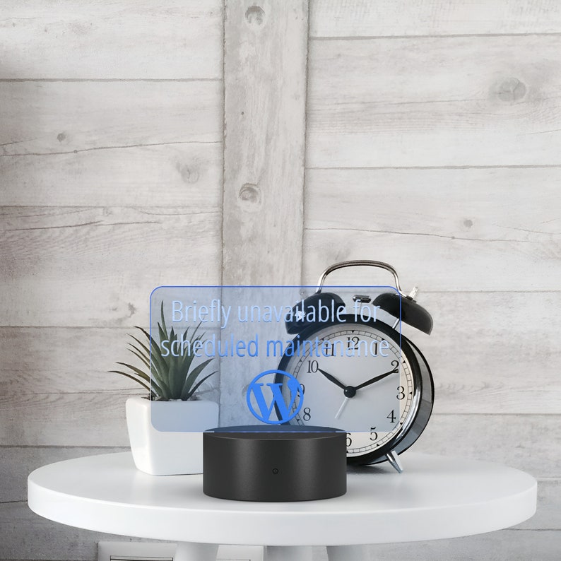 May include: A black alarm clock with a white face and black hands. The clock is set to 10:55. The clock is sitting on a white table next to a black lamp with a blue light that says "Briefly unavailable for scheduled maintenance".