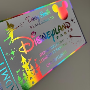 May include: A holographic Disneyland Paris admission ticket with rainbow text and graphics. The ticket features the name "Daisy Smith", a Mickey Mouse head, Tinkerbell, and a castle. The departure location is London St Pancras, with a date of 22/12/2025.