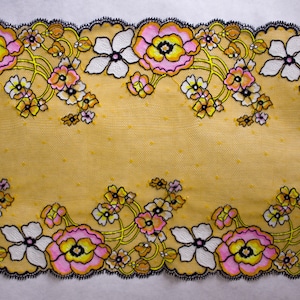 K&ouml;nnte beinhalten: Gelber Blumenspitzenbesatz mit schwarzem Rand und rosa und wei&szlig;en Bl&uuml;ten. Die Spitze hat ein Punkte-Muster.