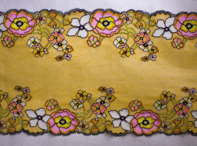 K&ouml;nnte beinhalten: Gelber Blumenspitzenbesatz mit schwarzem Rand und rosa und wei&szlig;en Bl&uuml;ten. Die Spitze hat ein Punkte-Muster.