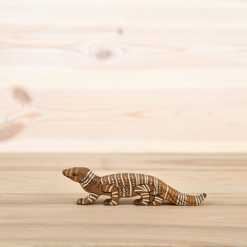 Handcrafted wooden goanna toy on white background