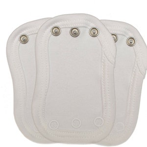 May include: Three white baby vests with snap closures. Each vest has three snaps at the top and three at the bottom. The vests are made of a soft, white fabric.