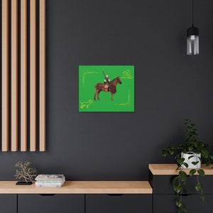 Puede incluir: Impresión en lienzo que presenta un guerrero a caballo sobre un fondo verde vibrante. La obra de arte muestra un caballo marrón con aparejos detallados, montado por una figura que sostiene una lanza. Elementos decorativos en las esquinas y una silueta de perro.