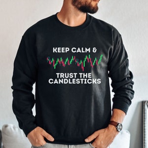 May include: Black sweatshirt with white text that reads "Keep Calm & Trust the Candlesticks". The text is accompanied by a graphic of a candlestick chart with green and red bars.