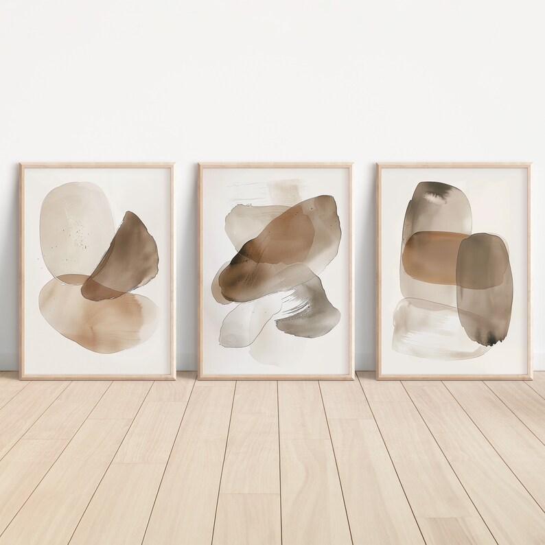 Puede incluir: Tres pinturas abstractas de acuarela enmarcadas con formas marrones y beige sobre un fondo blanco.