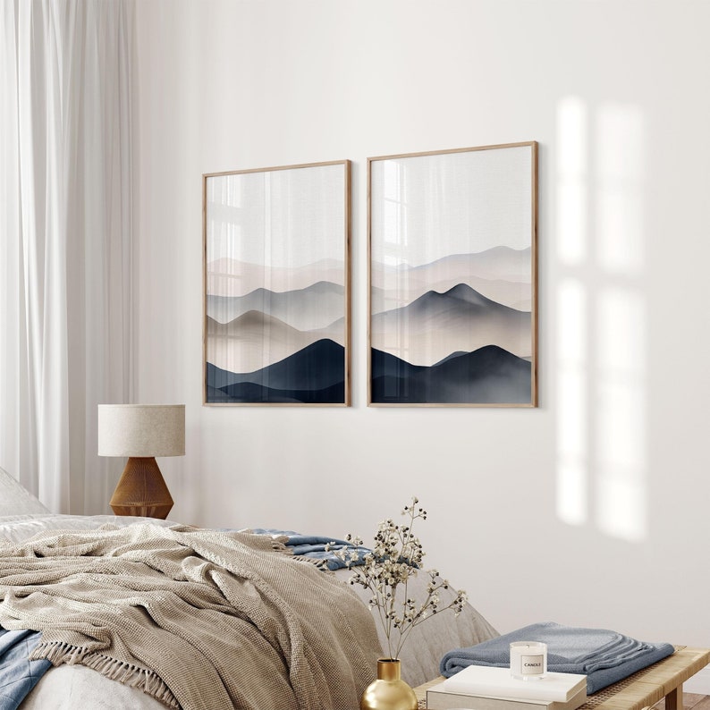 Puede incluir: Dos impresiones enmarcadas de pinturas abstractas de acuarela que representan una cadena monta&ntilde;osa brumosa en tonos de azul y rosa.