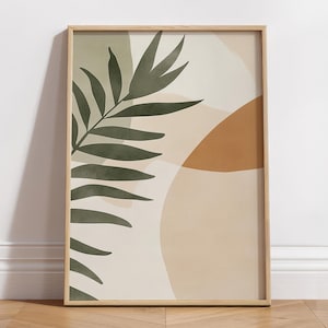 May include: Abstract art print with a green leaf and beige, brown, and orange shapes. The print is framed in a light wood frame.