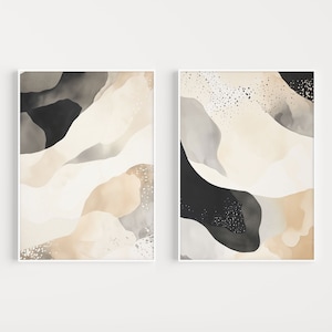 Op de afbeelding: Twee abstracte kunstprints met een witte achtergrond en zwarte en beige vormen. De prints hebben een moderne en minimalistische stijl.