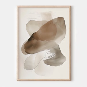 Puede incluir: Impresi&oacute;n de arte abstracto con formas de acuarela marrones y beige sobre un fondo blanco. La impresi&oacute;n est&aacute; enmarcada en un marco de madera claro.