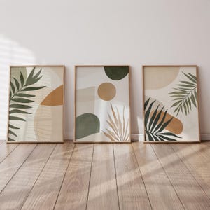 May include: Three framed abstract art prints with a minimalist design featuring green and brown leaves, geometric shapes, and a neutral background.