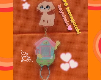 May include: A pink and blue plastic keychain featuring a small house with a window and the text "LPS" on the front. The keychain also includes a small, light brown dog with blue eyes. The keychain is surrounded by pink hearts and stars.