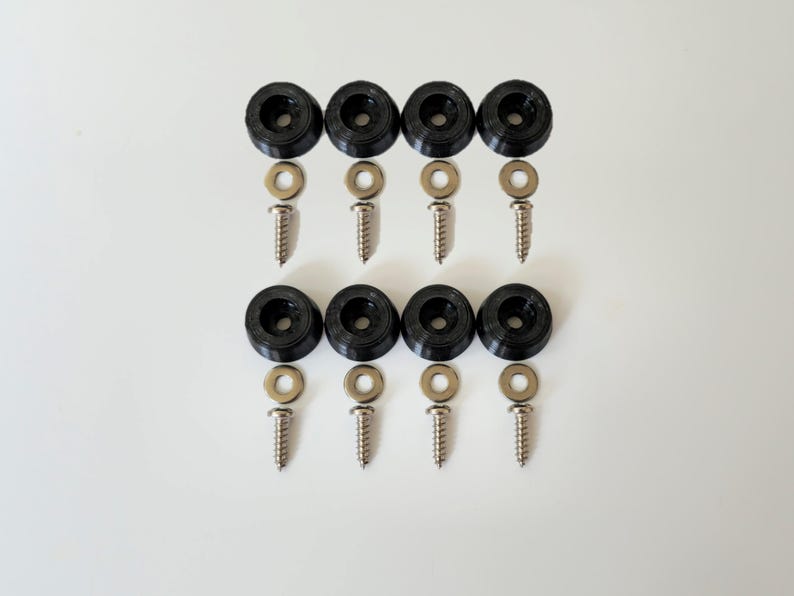 May include: A set of eight black rubber furniture feet with screws and washers. The feet are designed to protect floors from scratches and provide stability.