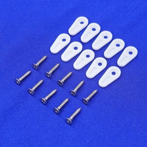 May include: A set of ten white plastic window clips and ten silver screws. The clips are oval-shaped with a small hole in the center. The screws are small and have a Phillips head.