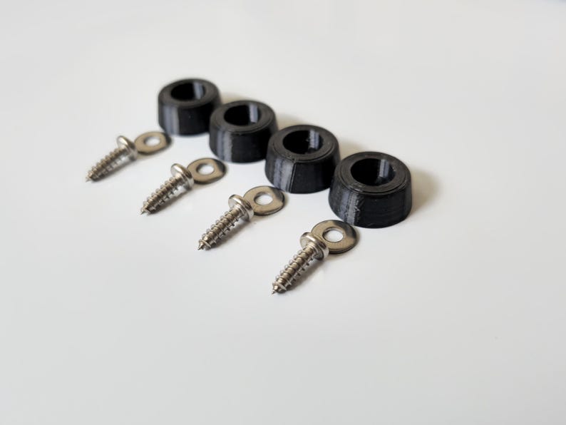 May include: Four black plastic furniture feet with a textured surface and four silver screws with washers.