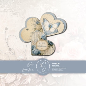 Heart-shaped no sew pocket folio in vintage blue hydrangeas and butterflies on cream — junk journal kit with pages, pockets, and ephemera, on a soft floral background.