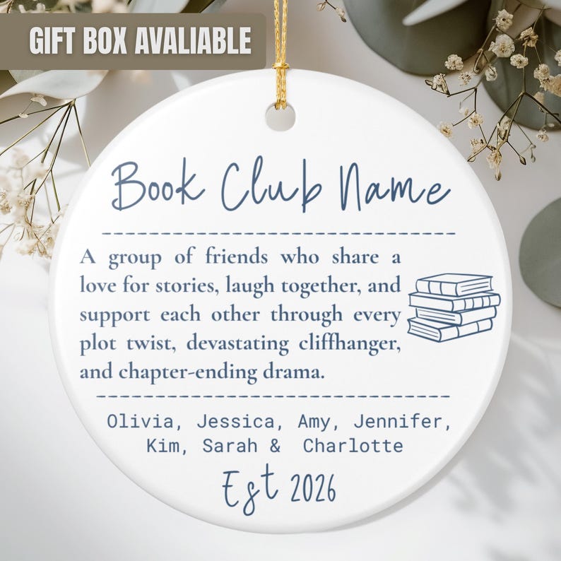 May include: A round white ceramic ornament featuring blue text that reads Book Club Name, followed by a definition of a book club, a stack of books illustration, the names Olivia, Jessica, Amy, Jennifer, Kim, Sarah, and Charlotte, and Est 2026.
