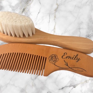 May include: A wooden comb and brush set with a rose design and the name "Emily" engraved on the comb. The set is made of natural wood and has a soft bristle brush.