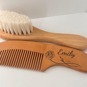 May include: A wooden baby hair brush and comb set with a rose and the name "Emily" engraved on the comb.