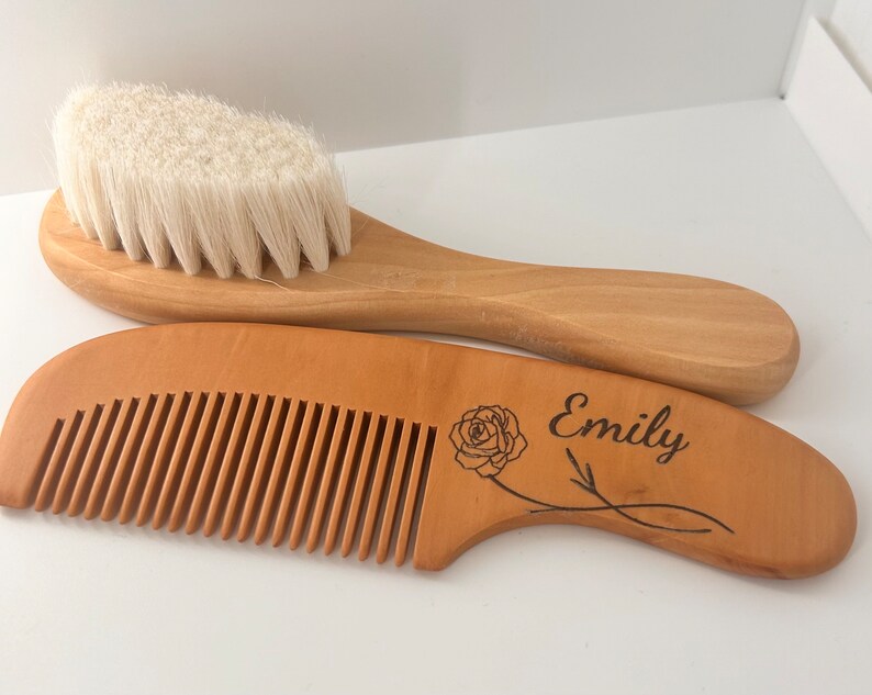 May include: A wooden baby hair brush and comb set with a rose and the name "Emily" engraved on the comb.