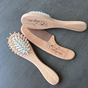 May include: Three wooden hair brushes with personalized names. The brushes are made of natural wood and have a soft bristle design. The names are "Evelyn Rose", "Evelyn Rose", and "Cozier Rose".