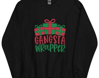 Pode incluir: Uma camisola preta de manga comprida com um gráfico de três caixas de presente em vermelho e verde. Abaixo dos presentes, o texto GANGSTA WRAPPER está impresso em letras vermelhas e verdes. A peça tem gola redonda e punhos e bainha canelados.