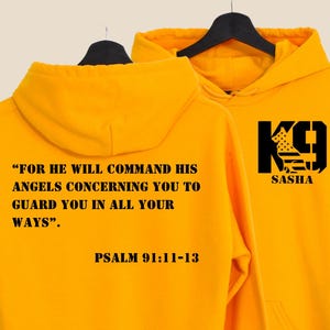 May include: Two golden yellow hoodies. One displays the text "FOR HE WILL COMMAND HIS ANGELS CONCERNING YOU TO GUARD YOU IN ALL YOUR WAYS". Below is "PSALM 91:11-13". The other hoodie has a black graphic of a dog and the word "SASHA" below it.