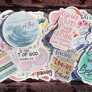 Könnte beinhalten: Eine Sammlung farbenfroher Aufkleber mit inspirierenden Zitaten und religiösen Themen. Die Aufkleber zeigen Sätze wie "Waves of the Sea", "Rejoice Always Pray" und "Strength and Dignity". Die Aufkleber sind in verschiedenen Formen und Größen.