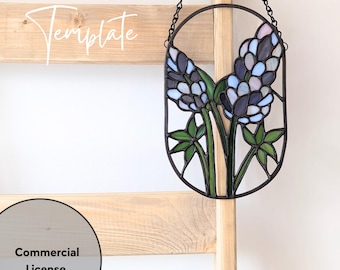 May include: A stained glass window hanging on a wooden ladder. The window is oval shaped and features a blue and purple flower design.