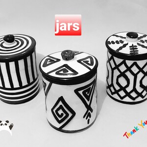 Könnte beinhalten: Drei schwarze und weiße Keramik-Gläser mit Deckeln. Die Gläser haben verschiedene geometrische Muster. Das Wort "Gläser" ist in roten Buchstaben über den Gläsern geschrieben.