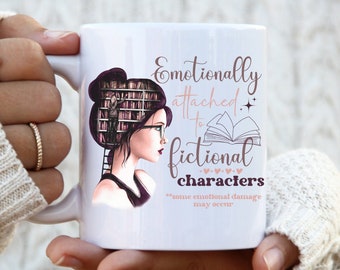 Può includere: Tazza in ceramica bianca con la scritta "Emotionally attached to fictional characters". La tazza presenta un'illustrazione di una donna con una biblioteca tra i capelli. È incluso anche il testo "some emotional damage may occur".