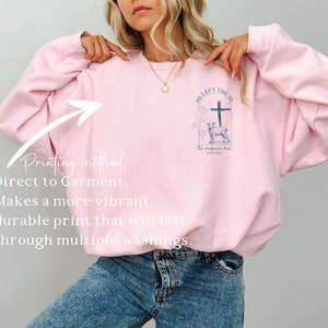 Pu&ograve; includere: Felpa rosa con una stampa grafica di una croce, un agnello e il testo "HE LEFT THE 99 to rescue me LUKE 15:4-7".