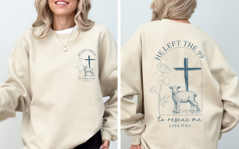 Pu&ograve; includere: Una felpa beige con una stampa grafica blu sul davanti e sul retro. La grafica presenta una croce, un agnello e il testo "HE LEFT THE 99 to rescue me LUKE 15:4-7".
