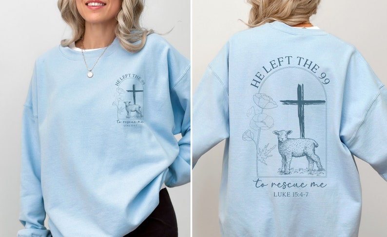 Pu&ograve; includere: Felpa blu chiaro con una stampa grafica di una croce e un agnello. Il testo sulla felpa recita "He left the 99 to rescue me Luke 15:4-7".